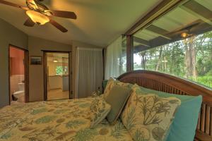 A bed or beds in a room at Tropical Cabana with Deck, Hot Tub and Lush Scenery!