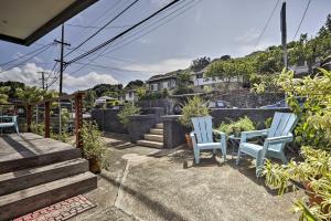 two blue chairs sitting on a patio with a view at Remodeled Honolulu Apartment with Courtyard Downtown in Honolulu