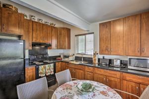 a kitchen with wooden cabinets and a table with a tableablish at Remodeled Honolulu Apartment with Courtyard Downtown in Honolulu