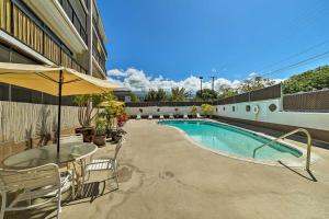 una piscina con tavolo e ombrellone di Downtown Air Conditioned Condo Walk to Beaches a Kailua-Kona