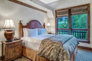 The Aspen Mountain Residences في أسبين: غرفة نوم بسرير كبير ونافذة