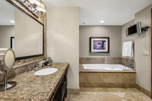 a bathroom with a tub and a sink and a mirror at The Aspen Mountain Residences in Aspen