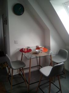 a table with two chairs and a table with cups on it at L'Escapade Lochoise in Génillé