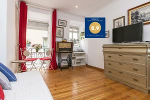 a bedroom with a bed and a dresser with a television at Romantic Apartment El Corte Inglês in Lisbon