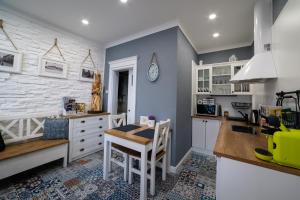 a kitchen with white cabinets and a table and a counter at Apartman Sv. Urban in Bratislava