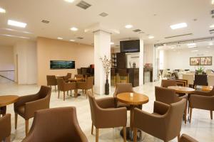 a restaurant with tables and chairs in a lobby at Hotel Athina in Lamía