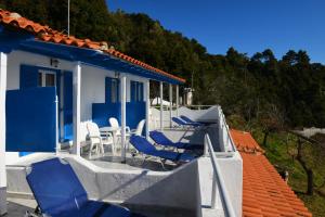 a house with blue and white chairs on a porch at Alexandra's Studios in Kechria