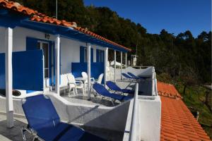 a house with blue and white chairs and a roof at Alexandra's Studios in Kechria