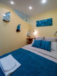 una camera da letto con un letto grande con cuscini blu di Sunny Old Town Apartments a Bucarest