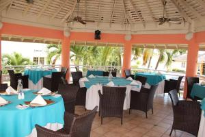 ein Restaurant mit blauen Tischen, Stühlen und Palmen in der Unterkunft E 20 Mystic Ridge ocho Rios in Ocho Rios