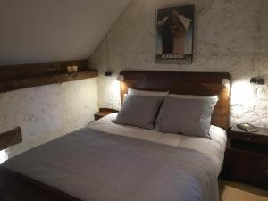 a bedroom with a large bed with two pillows at Les Bouaux, Lavena in Cussy-en-Morvan +13 photos