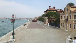 una acera junto a un cuerpo de agua con edificios en Casa Vacanze "Al Castello" Venezia en Venecia