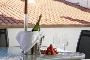 a bottle of champagne and strawberries on a table with glasses at Apartamentos Turísticos Centro in Granada