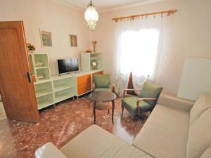 Casa Vacanze "Al Castello" Venezia في البندقية: غرفة معيشة بها أريكة وكراسي وتلفزيون