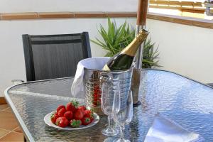 a bottle of champagne and a plate of strawberries on a table at Apartamentos Turísticos Centro in Granada