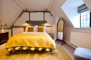 a bedroom with a large bed with a yellow bedspread at Cotswolds Place - Chancewell in Broadway