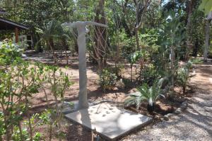 a statue of a bird standing in a garden at Pazifico Villas in Playa Avellana