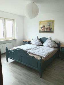 a bedroom with a blue bed with pillows on it at Penthouse "Michelangelo" GreatView, WiFi & Netflix in Schweinfurt