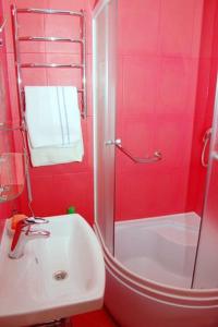 ein rotes Badezimmer mit einem Waschbecken und einer Dusche in der Unterkunft Sofiivs'ka Street, 1,, in Kiew