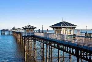 
a pier with a row of boats on top of it at Elsinore Hotel Llandudno in Llandudno
