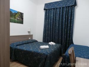 ローマにあるマルジエ インのベッドルーム1室(ベッド2台、タオル付)