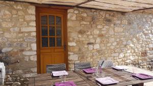 a wooden table in front of a stone building at Bienvenue Chez Romane in Aiguèze +18 photos
