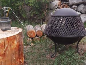 a grill sitting next to a pile of logs at Hoopoe Glamping in Virpazar