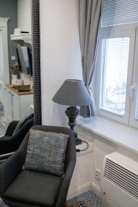 a living room with a chair and a lamp and a window at Apartman Sv. Urban in Bratislava