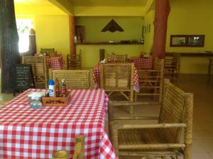 a restaurant with a red and white checkered table and chairs at Ruan Mai Naiyang Beach Resort in Nai Yang Beach