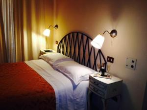 1 dormitorio con 1 cama con 2 lámparas en Marta Guest House, en Roma