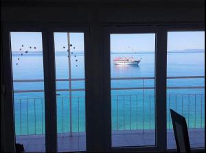 een raam met uitzicht op een boot in het water bij Adriatic Deluxe in Dugi Rat