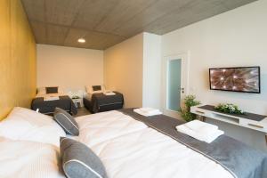a bedroom with two beds and a tv on the wall at Residence Trafick in Prague