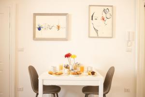 una mesa de comedor blanca con sillas y comida. en Vincent Suite Luxury B&B, en Palo del Colle