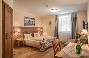 a hotel room with a bed and a table and a dining room at Hotel Wirt z´ Engelsberg in Engelsberg