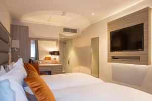 a hotel room with two beds and a flat screen tv at Metro Hotel Dublin Airport in Santry