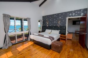 a bedroom with a bed and a large window at Dua Dua Beach Resort in Rakiraki +65 photos
