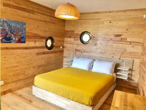 um quarto com paredes de madeira e uma cama amarela em The Place em Ponta Delgada
