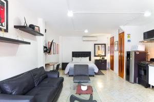 een woonkamer met een bank en een bed bij Studios Exito in Medellín