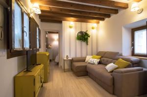 a living room with a couch and a tv at La Casa del Tránsito - Living Toledo in Toledo