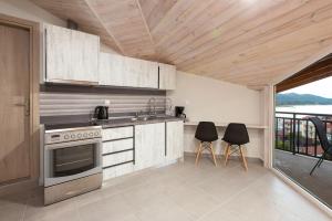 a kitchen with a stove and two chairs in it at Villa Theasi in Olympiada