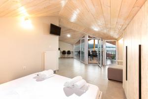 a bedroom with a white bed and a living room at Villa Theasi in Olympiada