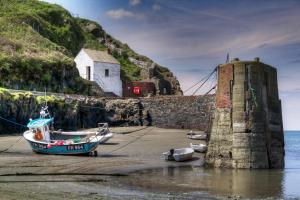 um barco sentado na praia ao lado de uma ponte em Ash rock House em Haverfordwest