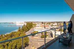 
a person sitting on a balcony looking out over the water at Port Lincoln Hotel in Port Lincoln
