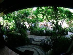 a view of a garden with a bench and trees at Seahua Ha Ha Tulamben Dive Resort in Tulamben