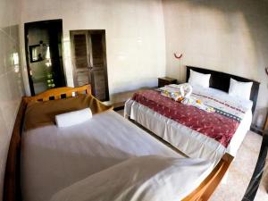two beds in a room with two bedsskirts at Seahua Ha Ha Tulamben Dive Resort in Tulamben