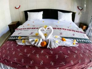 two swans made out of towels on a bed at Seahua Ha Ha Tulamben Dive Resort in Tulamben