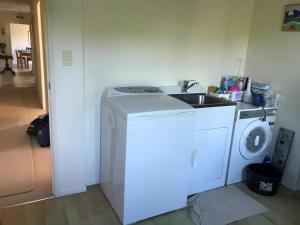 a kitchen with a washing machine and a sink at Fieldays Dream in Tamahere