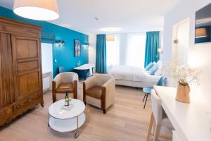 una camera d'albergo con un letto e un soggiorno di Berdorfer Eck - Bed&Breakfast a Berdorf