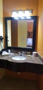 a bathroom with a sink and a large mirror at Lotus by Hotel Inn in Ontario