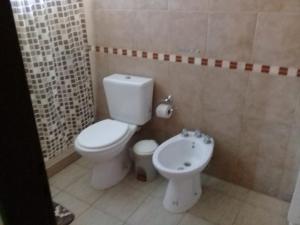 y baño con aseo blanco y lavamanos. en Complejo Antares en San José